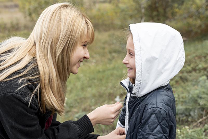 1753796223_lateral_view_careful_woman_arranging_daughter_jacket.jpg